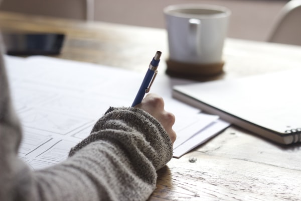 Postgraduate learner planning research notes at a desk
